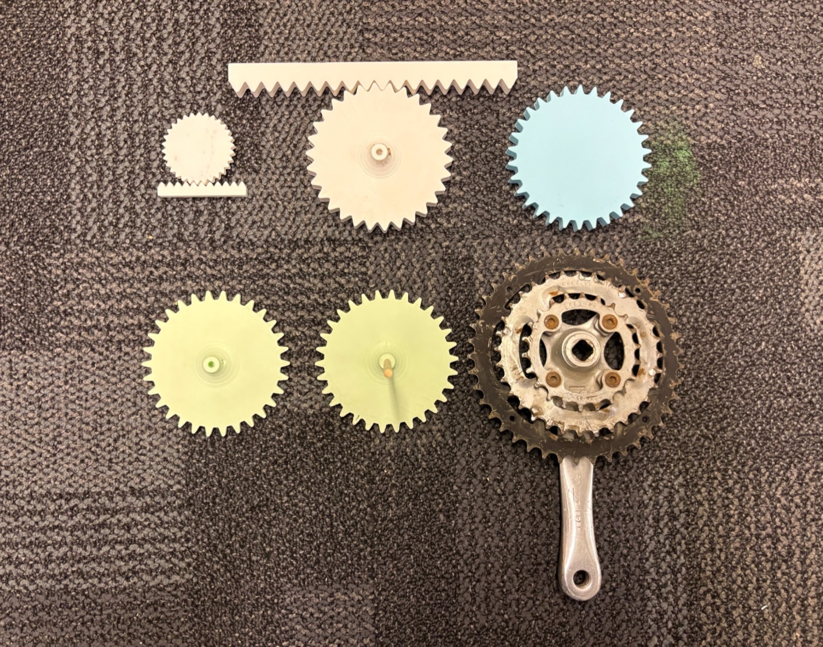 Gear iterations in PLA alongside the salvaged bike sprocket